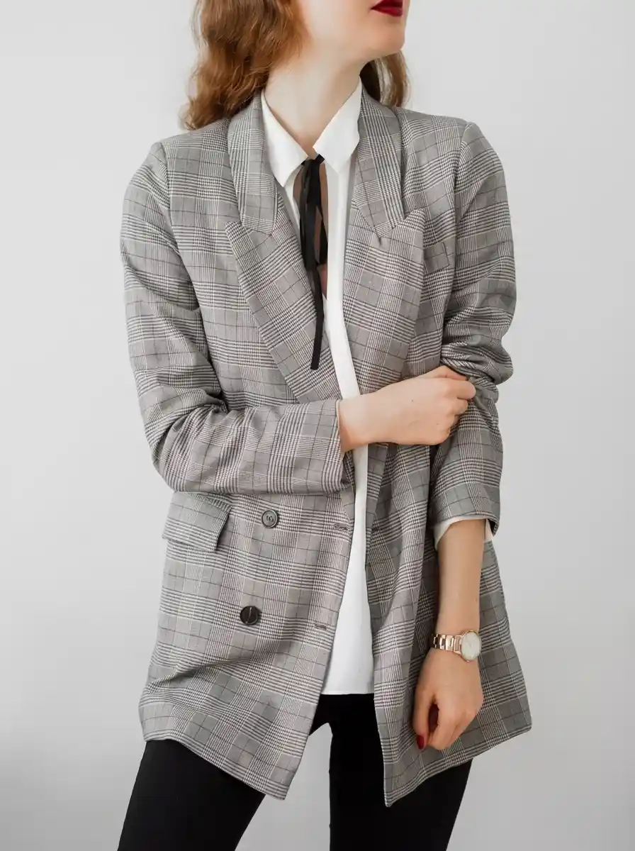 Woman wearing a gray blazer with straight-leg black trousers