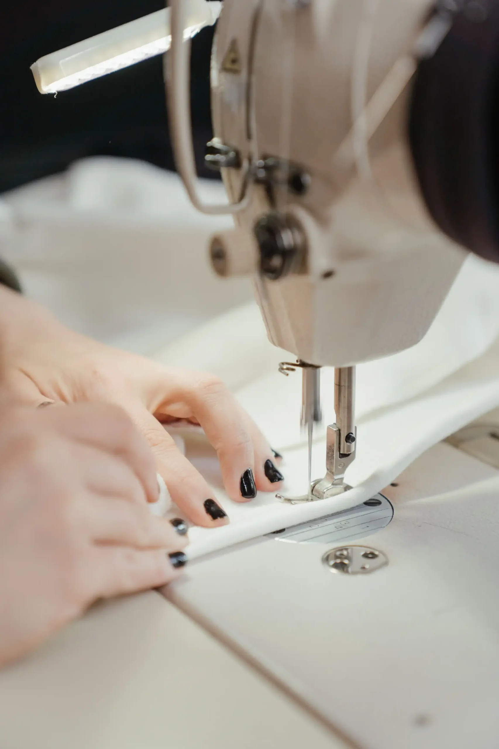 Macro photography of a deep blind-stitched hem on a wool skirt showing structural tailoring and clean seam finishes.