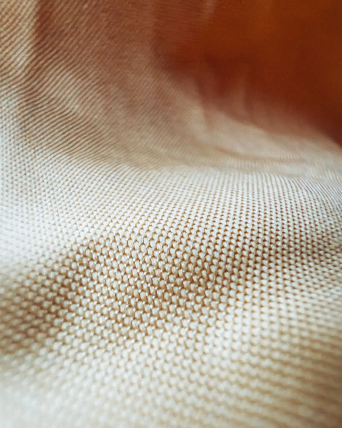 Close-up of a beige woven suiting fabric showing a matte textured surface