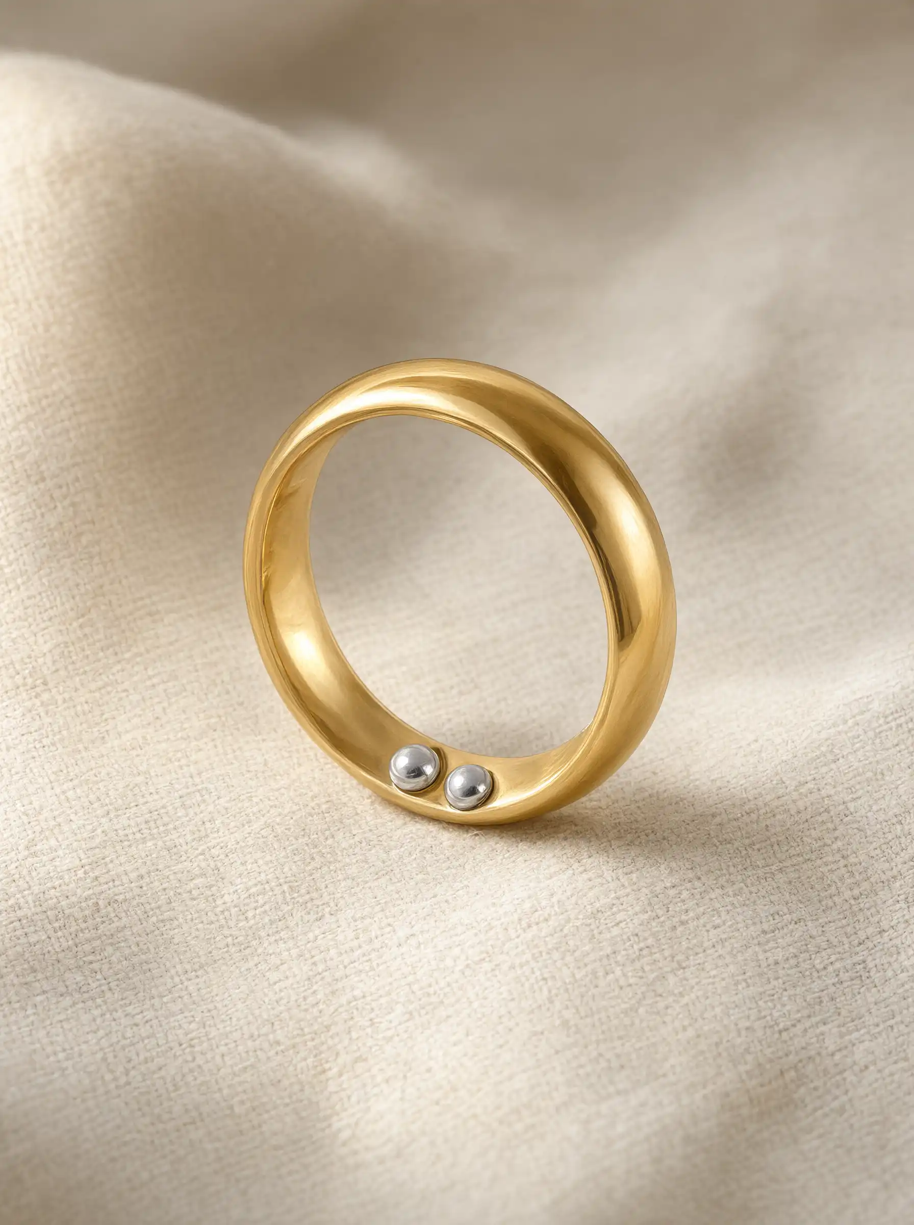 A woman's hand wearing several stacked rings in mixed metals