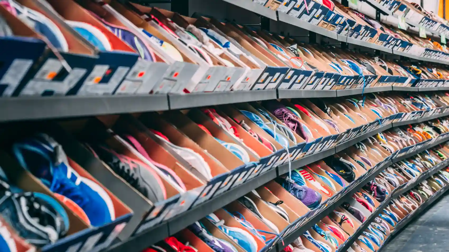 Sneakers stored in boxes on wooden shelves inside a boutique